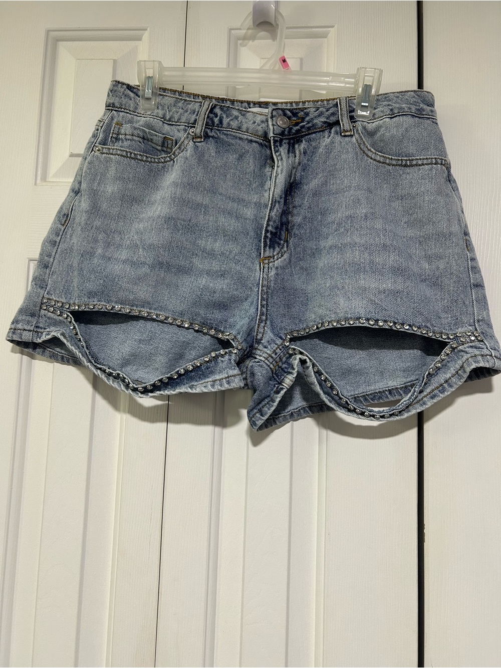 blue denim shorts with cutouts and rhinestones studs along the hem